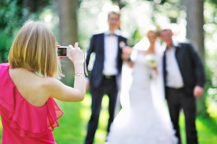 Girl photographing guests at a wedding.