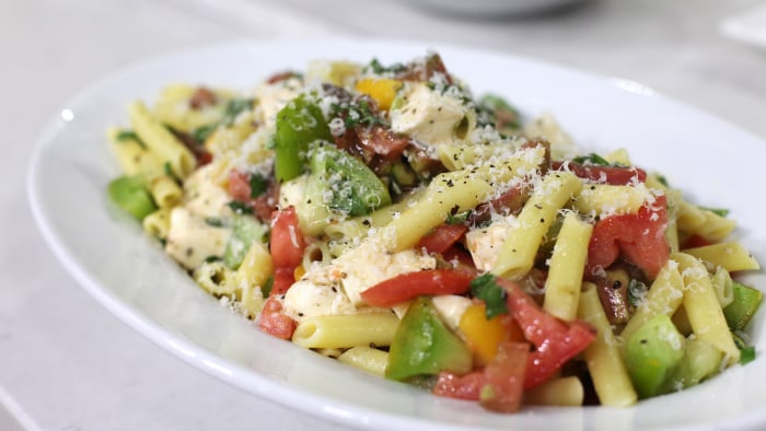 Penne pasta with heirloom tomatoes, grated parmesan cheese, basil and other ingredients. 