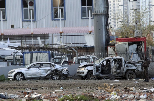 Image: A member of the police special forces stands next to vehicles, which were damaged by a car bomb attack that targeted a minibus carrying members of the police special forces, occurred in Diyarbakir