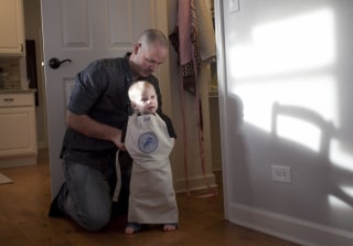 David Juip puts a apron on his son Ari, 1, while making dinner at their home.