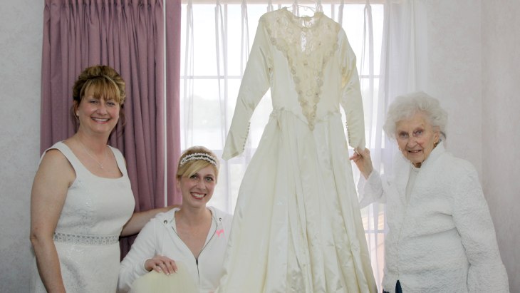 IMAGE: Cindy, Jackie, and Helene pose with their wedding dress.