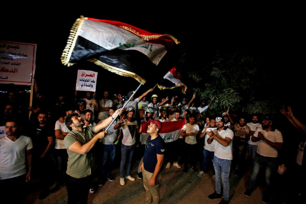 Image: Iraqi people celebrate after Kirkuk was seized by Iraqi forces as they gather on the street of Baghdad