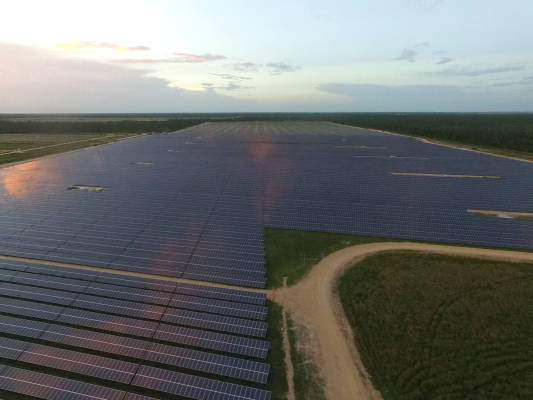 aerial view over solar field at sunset