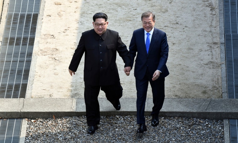 Image: Kim Jong Un and Moon Jae-in cross the military demarcation line at Panmunjom