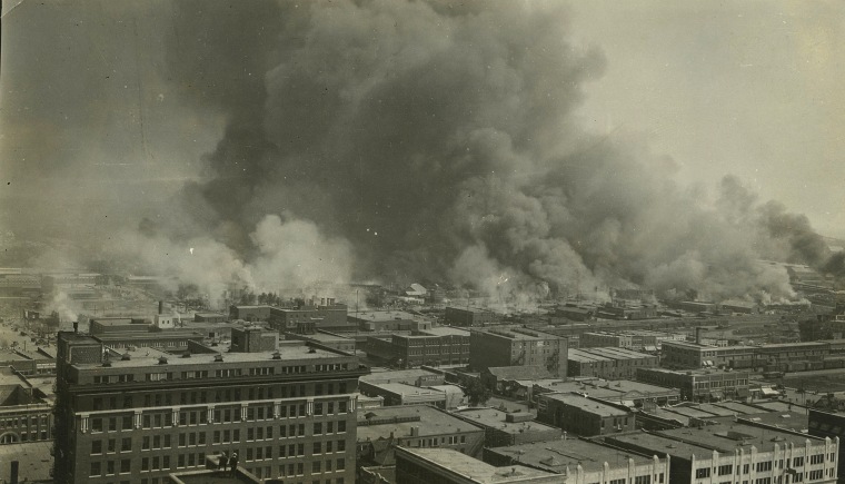 Image: Smoke rises over Tulsa's Greenwood District during race riots in 1921