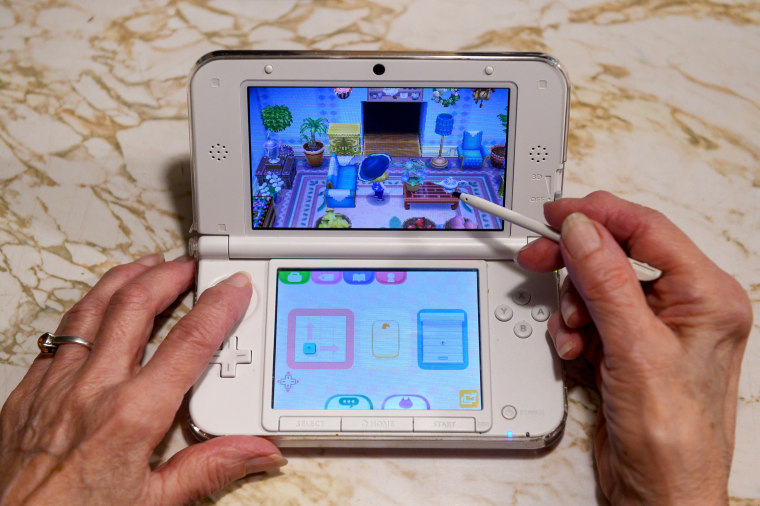Image: Audrey Buchanan, 88, plays Animal Crossing on her pink Nintendo 3DS XL