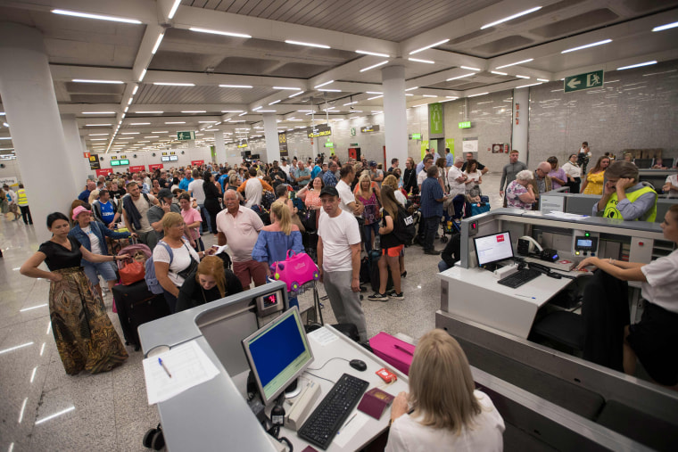 Image: Thomas Cook passengers line up at Son Sant Joan airport in Palma de Mallorca 