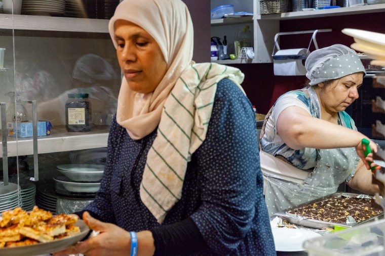 Kholoud Marei, left, and Maryam Khoshluie prepare Middle Eastern sweets to go with tea and other hot drinks during one of the community's events held at Orient Experience.