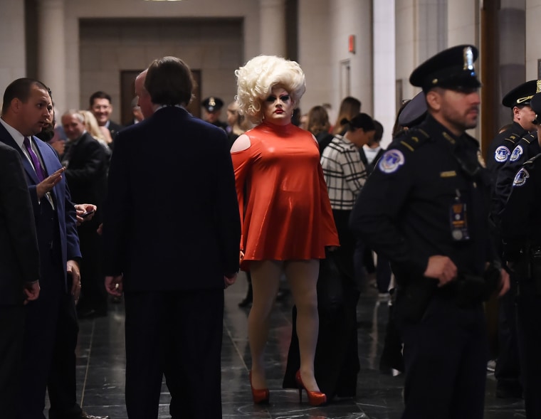 Image: A drag queen stands in the hallway of the Longworth building as people await the arrival of the first two witnesses to testify before the House Intelligence Committee for the first public impeachment hearing