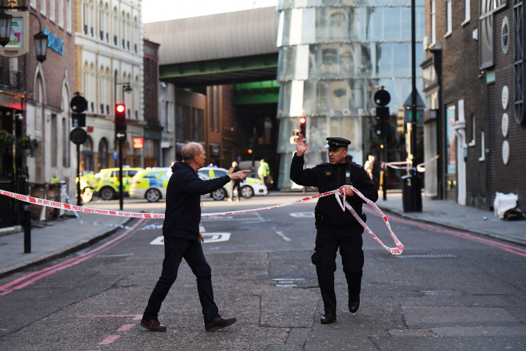 Image: Members of the public are held behind a police cordon near London Bridge train station 