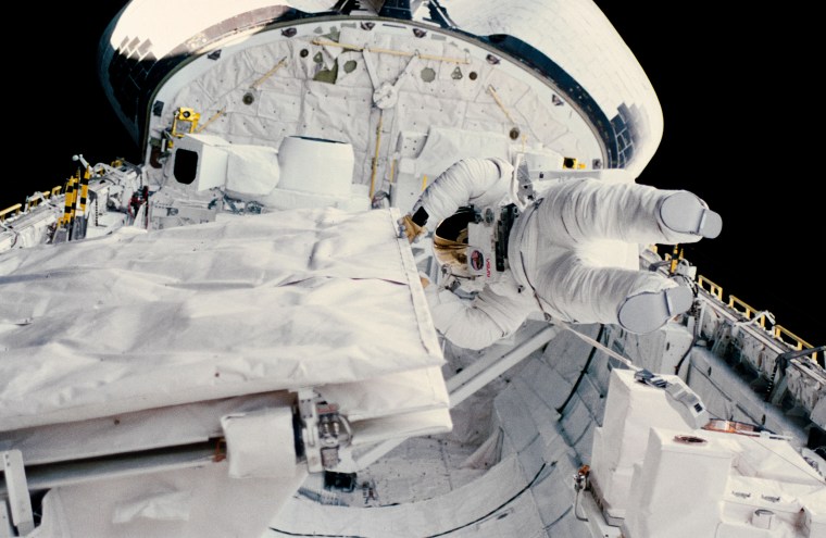 Astronaut Kathryn D. Sullivan checks the latch of the SIR-B antenna in the space shuttle Challenger's open cargo bay during her historic extravehicular activity (EVA) on Oct. 11, 1984.