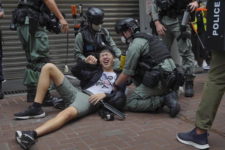 Image: A reporter falls down after being sprayed with pepper spray by police during a protest in Causeway Bay during the annual handover march in Hong Kong