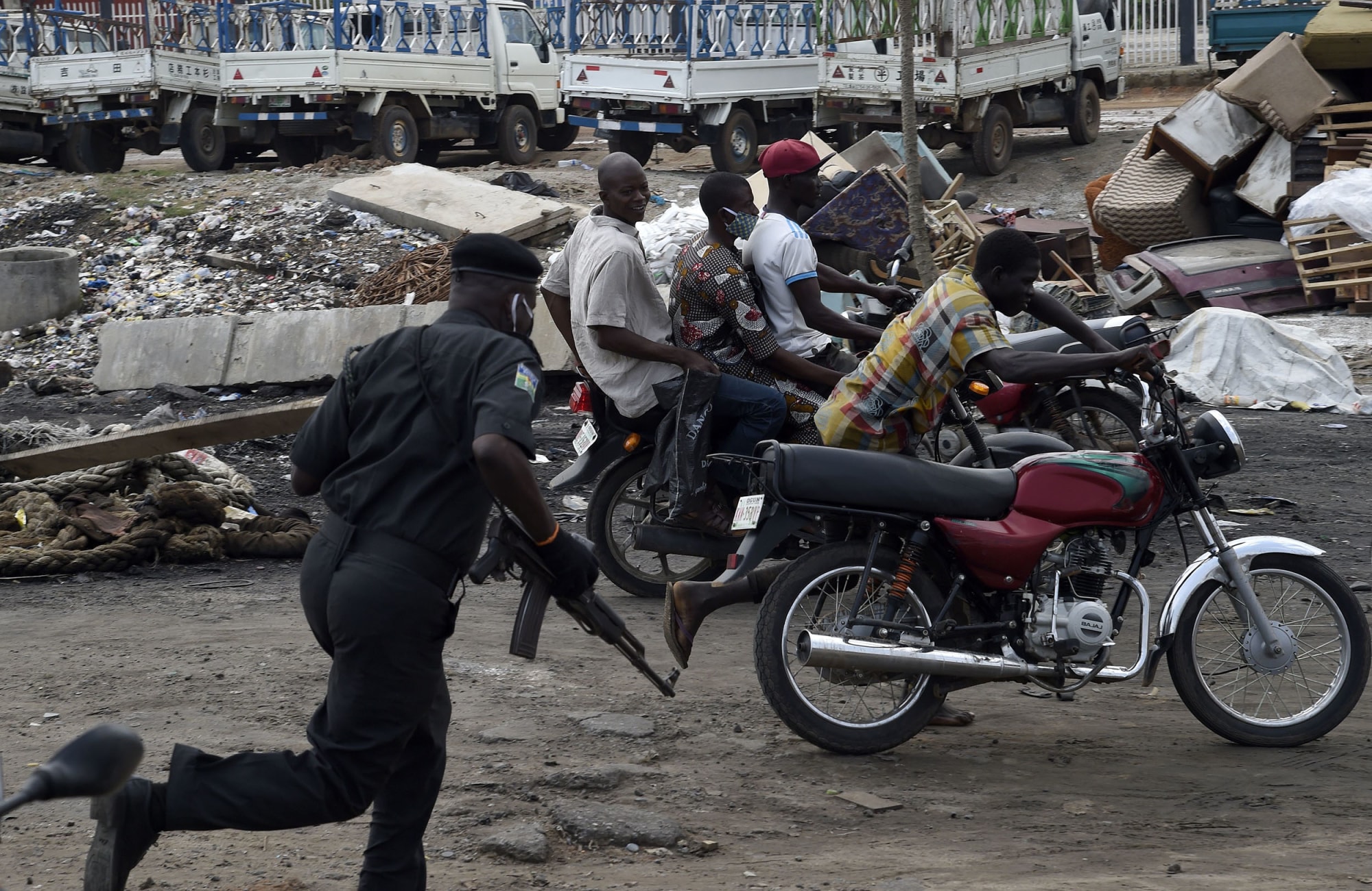 IMage: A police officer pursues fleeing motorcycle taxi riders who refused to stop at mounted barricades to check movement of vehicles and for failing to comply with the sit-at-home order to prevent the spread of COVID-19 coronavirus on Lagos Ibadan expre