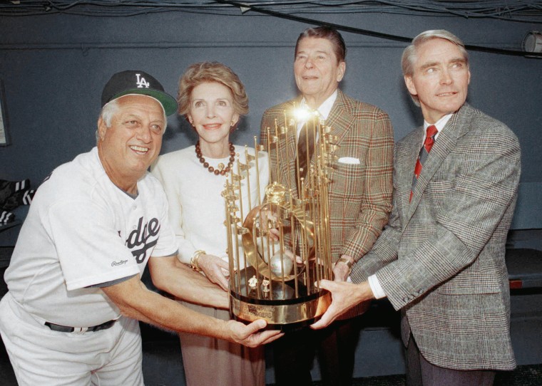 Dodgers manager Tommy Lasorda, left, shares one of the Los Angeles Dodgers' World Championship trophies with former President Ronald Reagan, Nancy Reagan, and Dodgers executive vice-president Fred Claire, right, before home opener at Dodger Stadium in Los Angeles on April 13, 1989.