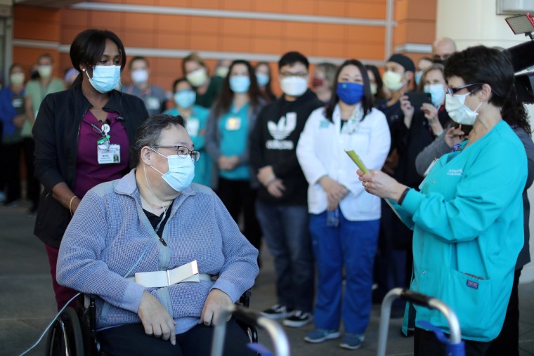 Image: A medical worker reads a poem to Daniel Kim, 48, as he leaves St. Jude Medical Center after five months after surviving the coronavirus disease in Fullerton