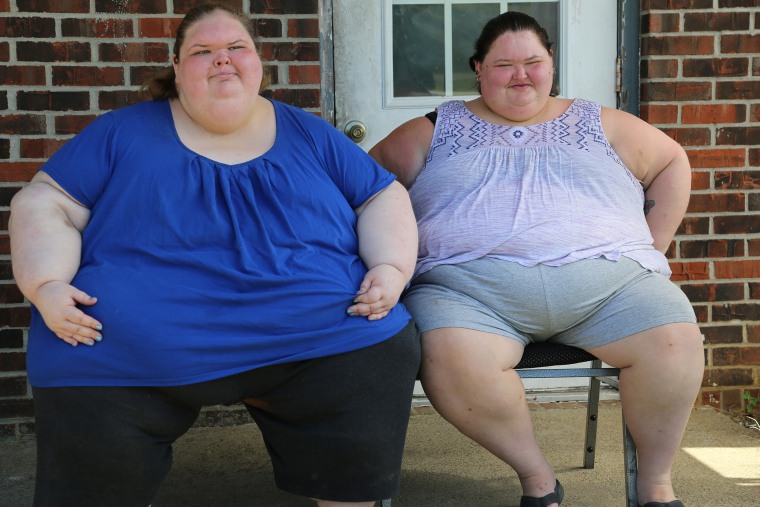 "1000-lb. Sisters" stars Tammy and Amy Slaton pose together on their front porch. 